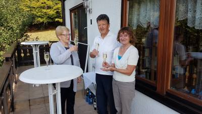 Herr und Frau Schmitt mit Gabriele Rauxloh beim Anstoen auf den 75. Geburtstag